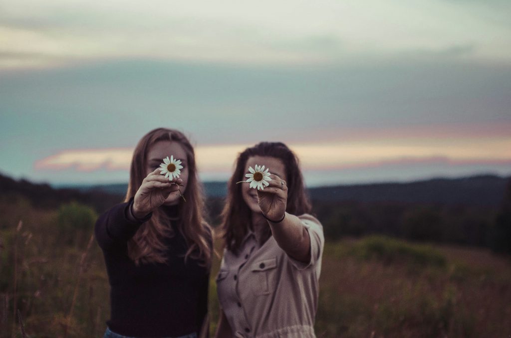 Two girls holding flower